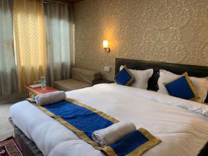 a bedroom with a large bed with blue and white pillows at Hill Side Cabin, Pangong in Spangmik
