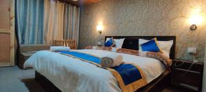 a bedroom with a large bed with blue and white sheets at Hill Side Cabin, Pangong in Spangmik