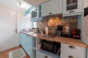 a kitchen with blue cabinets and a counter top at Avgi's House Pelekas in Pelekas