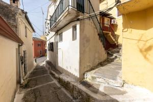 an alley with a white and yellow building at Avgi's House Pelekas in Pelekas