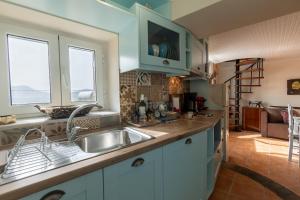 a kitchen with a sink and two windows at Avgi's House Pelekas in Pelekas