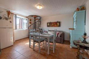 a dining room with a white table and chairs at Avgi's House Pelekas in Pelekas +28 photos