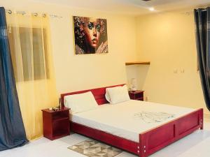 a bedroom with a bed with a painting on the wall at Bulle d'Or PREMIUM in Libreville