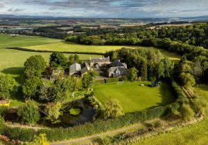 an aerial view of a large house in a green field at The Studio at Pitmeadow Farm in Dunning