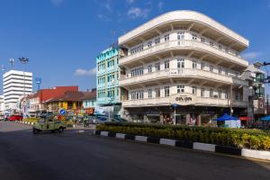 a large white building on the side of a street at GinGin Hotel, Trang Old Town in Trang