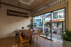 a dining room with a table and chairs in front of a store at GinGin Hotel, Trang Old Town in Trang
