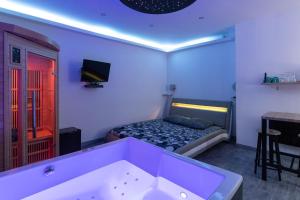 a bathroom with a tub and a bed in a room at LX202 Love Room & Spa privatif - Jacuzzi & Sauna in Dijon