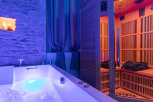 a large bathroom with a tub with a mirror at LX202 Love Room & Spa privatif - Jacuzzi & Sauna in Dijon