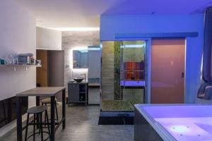 a kitchen with a tub and a table and chairs at LX202 Love Room & Spa privatif - Jacuzzi & Sauna in Dijon