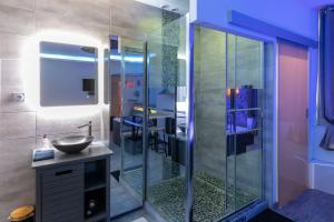 a bathroom with a glass shower with a sink at LX202 Love Room & Spa privatif - Jacuzzi & Sauna in Dijon
