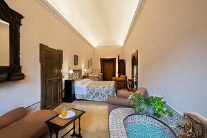 a hotel room with a bed and a living room at Relais Villa Giusso in Vico Equense