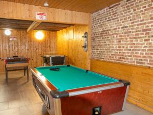 a pool table in a room with a brick wall at Camping les 3 Sablières in Saint-Firmin