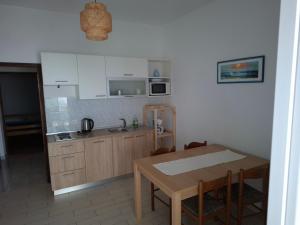 a kitchen with white cabinets and a table and a table and chairs at Apartments Mara Mandre in Mandre +13 photos