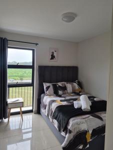 a bedroom with a bed and a large window at Tettey Haven Millennial in Durban