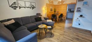 a living room with a couch and a table at Feriendorf Hochbergle Haus 34 in Lechbruck +37 photos