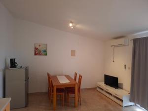 a living room with a table and a refrigerator at Apartments Mara Mandre in Mandre