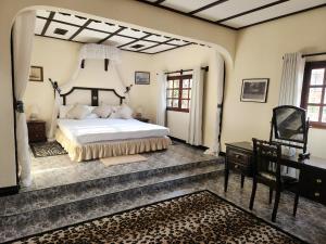 a bedroom with a large bed and a desk at Kilulu Luxury Island, Watamu in Watamu