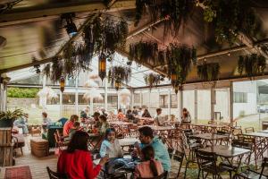 a group of people sitting at tables in a restaurant at Daft Hotel & Glamping in Malmedy