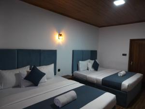 two beds in a room with two beds sidx sidx sidx sidx at Ru Hotel & Villa in Nuwara Eliya