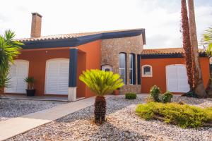a house with palm trees in front of it at Verde Verdilhão Villa in Arazede