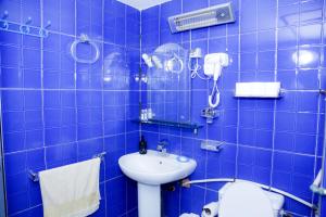 a blue tiled bathroom with a toilet and a sink at maison avec deux chambres climatisées in Er Rachidia +108 photos