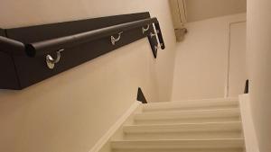 a stairway with a black rail and white stairs at B&B Velddriel in Velddriel +15 photos