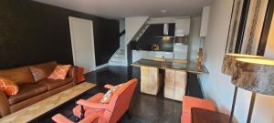 a living room with orange chairs and a couch at B&B Velddriel in Velddriel