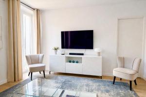 a living room with a tv and two chairs at Luxury Elegance Comfort 3-room apartment of 80m2 with 2 BDR 2 BA 3 min Croisette & Beach in Cannes