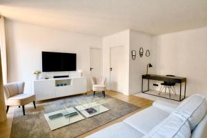 a living room with a white couch and a flat screen tv at Luxury Elegance Comfort 3-room apartment of 80m2 with 2 BDR 2 BA 3 min Croisette & Beach in Cannes