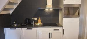 a kitchen with white cabinets and a black wall at B&B Velddriel in Velddriel