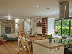 a kitchen and living room with a table and chairs at The Steading at Pitmeadow Farm in Dunning