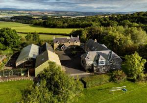 an aerial view of a large house in a field at The Steading at Pitmeadow Farm in Dunning