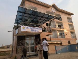 a group of people standing outside of a building at Refuge Des Princes in Douala