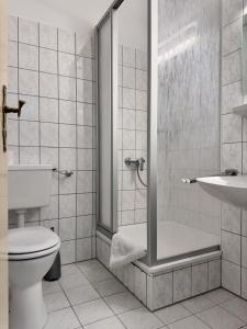 a bathroom with a shower and a toilet and a sink at Kurhaus im Harz - Bad Harzburg in Bad Harzburg +18 photos