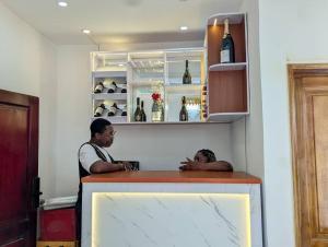 two men standing at a bar in a room at Refuge Des Princes in Douala