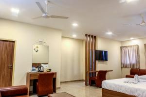 a hotel room with a bed and a desk and a mirror at Hotel M S Chola in Chennai