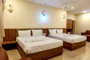 two beds in a hotel room with at Hotel M S Chola in Chennai