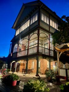 a large building with a balcony and a table at Elsmere Heritage Gardens & Accom in Launceston