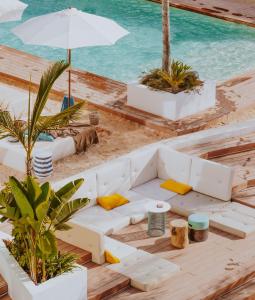ein weißes Sofa am Strand mit dem Wasser in der Unterkunft Nativo Hotel Ibiza by NCalma Hotels in Santa Eulària des Riu