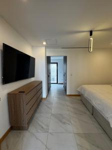 a bedroom with a bed and a flat screen tv at Penthouse Panoramic Terrace, San Felipe in Chihuahua