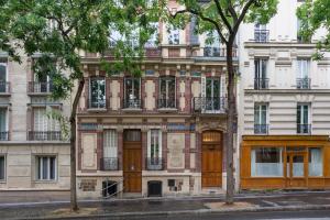 an apartment building with wooden doors and windows at Maison 1887 in Paris