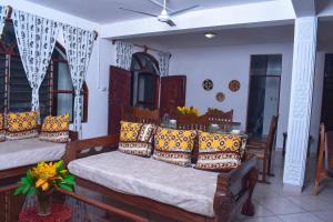 a living room with two beds with pillows at Kasa First Apartment in Mtwapa +33 photos