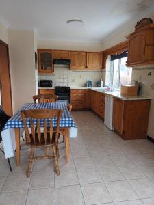 a kitchen with a table and a table and chairs at Hook Lighthouse Cottage in Ramsgrange