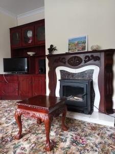 a living room with a fireplace and a coffee table at Hook Lighthouse Cottage in Ramsgrange