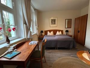 a bedroom with a bed and a desk with a sink at Schloss Spiegelberg in Neustadt