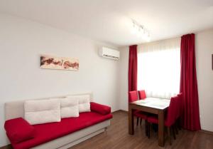 sala de estar con sofá rojo y mesa en Sofia Top Apartments, en Sofía