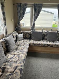 a couch with pillows sitting in front of a window at Caravan at the seaside in Great Yarmouth +43 photos