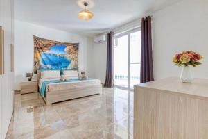 a bedroom with a bed and a large window at Bright & Spacious 3 Bedroom Apartment close to Marsaskala seafront in Marsaskala
