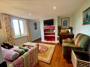 a living room with a couch and a fireplace at Elsmere Heritage Gardens & Accom in Launceston