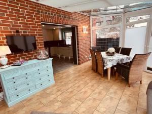 a dining room with a brick wall and a table and chairs at Ferienwohnung Dietje in Stedesdorf +3 photos